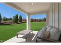Relaxing covered patio overlooking a lush green lawn and landscaped backyard at 1424 Rollman Farm Rd, Garner, NC 27603