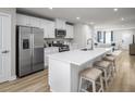 Bright kitchen showcasing white cabinets, stainless appliances, and a large island connecting to the open living area at 1424 Rollman Farm Rd, Raleigh, NC 27603