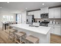 Modern kitchen features white cabinets, stainless steel appliances, and a large island with bar stool seating at 1424 Rollman Farm Rd, Raleigh, NC 27603