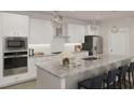 Modern kitchen featuring white cabinetry, granite countertops, and stainless steel appliances at 2000 Kapalua Way # 187, Durham, NC 27703