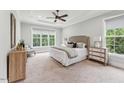 Serene bedroom with soft blue walls, neutral carpet, and a large window offering a calming view of nature at 2028 Pleasant Forest Way, Wake Forest, NC 27587