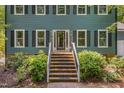Welcoming front entrance with a brick staircase, a storm door, and manicured bushes at 207 Old Forest Creek Dr, Chapel Hill, NC 27514