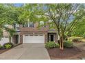 Charming brick townhome with a two-car garage, manicured landscaping, and a welcoming entrance at 2073 Weston Green Loop, Cary, NC 27513