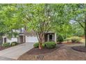 View of the brick facade, two car garage, driveway, and landscaping of this charming townhome at 2073 Weston Green Loop, Cary, NC 27513