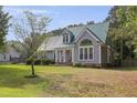 Beautiful single-Gathering home featuring a green metal roof, landscaped lawn, and inviting front porch at 213 Birch Creek Dr, Fuquay Varina, NC 27526
