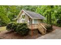 Charming home featuring stone accents, a spacious deck, and surrounded by lush greenery at 222 Sagamore Dr, Louisburg, NC 27549