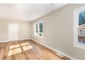 Bright living room with newly installed hardwood floors and fresh paint, illuminated by natural light from windows at 2312 Shannon St, Raleigh, NC 27610