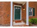 Front door of brick home with green door and storm door. Well lit and welcoming at 2459 Bay Harbor Dr, Raleigh, NC 27604