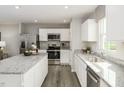 Bright kitchen with stainless steel appliances, white cabinets and granite countertops at 260 Day Farm Dr, Lillington, NC 27546