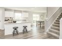 Open concept kitchen features an island with seating and a view of the dining area at 260 Day Farm Dr, Lillington, NC 27546