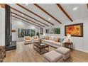 Bright living room with hardwood floors, vaulted ceiling with beams, fireplace, and large windows at 2600 Wade Ave, Raleigh, NC 27607