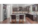 Modern kitchen with granite countertops, stainless steel appliances, and dark wood cabinetry at 3304 Rockland Ridge Dr, Cary, NC 27519