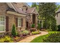 Charming home exterior featuring brick, stone accents, shutters, professional landscaping, and a stone walkway at 3601 Nightfall Ct, Raleigh, NC 27607