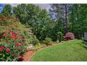 Beautiful backyard featuring lush landscaping, mature trees, and vibrant flower beds at 372 Farnleigh Dr, Chapel Hill, NC 27517