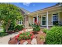 Inviting home exterior with a well-manicured lawn, stone accents, and covered front porch at 372 Farnleigh Dr, Chapel Hill, NC 27517