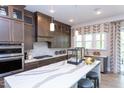 Spacious kitchen featuring an island with white countertops, stainless steel appliances, and wooden cabinets at 45 Little Gem Ln, Fuquay Varina, NC 27526