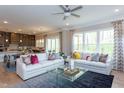 Bright living room with hardwood floors, two white sofas, and open view to the kitchen at 45 Little Gem Ln, Fuquay Varina, NC 27526