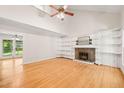Spacious living room with vaulted ceilings, hardwood floors, and fireplace with built-in shelving at 4500 Lancashire Dr, Raleigh, NC 27613