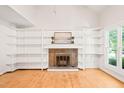 Bright living room featuring fireplace with built-in shelving and a sun-drenched window at 4500 Lancashire Dr, Raleigh, NC 27613