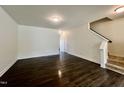 Spacious living room featuring sleek dark hardwood floors and stairway access to the upper level at 4716 Princess Lita Way, Raleigh, NC 27610