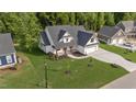 An aerial view of a home that features an attached three-car garage and lush landscaping at 525 Allesandra Dr, Clayton, NC 27527
