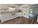 Kitchen features modern appliances, granite countertops, white cabinets and updated flooring at 5401 Lower Creek Ct, Apex, NC 27539