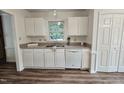 Bright kitchen features white cabinets, updated countertops and stainless steel sink beneath a window at 5401 Lower Creek Ct, Apex, NC 27539