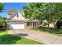 Traditional home showcasing a two-car garage, inviting front porch, and a long driveway at 5404 Onyx Mill Ct, Raleigh, NC 27616