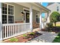 Inviting front porch featuring stone accents, decorative wreath, and manicured landscaping at 5404 Onyx Mill Ct, Raleigh, NC 27616