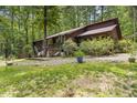 Spacious home exterior with expansive yard, patio, and lush surrounding greenery at 5604 Hideaway Dr, Chapel Hill, NC 27516