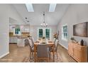 Open-concept dining area with hardwood floors, skylights, and French doors leading to outdoor space at 5804 Heatherbrook Cir, Raleigh, NC 27612
