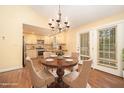 Warm dining room featuring an elegant chandelier, wooden table, and a view of the kitchen at 5804 Heatherbrook Cir, Raleigh, NC 27612