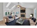 Bright living room features vaulted ceiling, skylights, a brick fireplace, and hardwood floors at 5804 Heatherbrook Cir, Raleigh, NC 27612