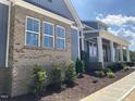 A close-up of the home's exterior with brick accents and tidy, attractive landscaping at 60 Stream View Way, Spring Hope, NC 27882