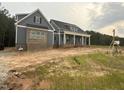 Beautiful single-Gathering home featuring blue siding, brick accents, and a charming front porch with columns at 60 Stream View Way, Spring Hope, NC 27882