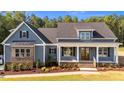 Inviting exterior of a two-story home, featuring blue siding, a welcoming front porch, and professional landscaping at 60 Stream View Way, Spring Hope, NC 27882