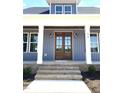 Inviting front porch with double doors, classic columns, and brick steps at 60 Stream View Way, Spring Hope, NC 27882
