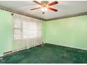 Bedroom featuring green walls, neutral trim and carpet, with a ceiling fan, waiting for the new homeowner's personal touch at 605 Mace Rd, Mebane, NC 27302