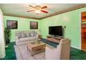 Inviting living room with light green walls, plush seating, a ceiling fan, and natural light creating a relaxing atmosphere at 605 Mace Rd, Mebane, NC 27302