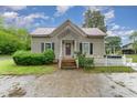 Cozy house featuring a red roof, covered porch, and a well-maintained yard at 6720 Dwight Rowland Rd, Willow Springs, NC 27592