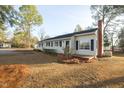 Well-maintained single-story home featuring a brick chimney, and manicured lawn with mature trees at 75 Hartwell Cir, Lillington, NC 27546