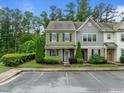 View of townhome featuring green siding, stone accents, manicured landscaping, and convenient parking at 7871 Allscott Way, Raleigh, NC 27612