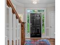 Inviting foyer with hardwood floors, staircase and a view to the exterior through a glass-panelled front door at 7929 Pine Timber Dr, Raleigh, NC 27613