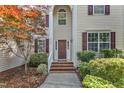 Inviting front entrance with a classic door, brick steps and a well-manicured garden at 8504 Delavan Cir, Raleigh, NC 27613