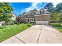 Lovely home featuring a well-manicured lawn, mature trees, and a two-car garage at 9 Sandhill Ln, Durham, NC 27713