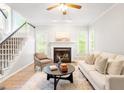 Cozy living room with a fireplace, large windows, staircase, and comfortable seating at 9400 Leslieshire Dr, Raleigh, NC 27615