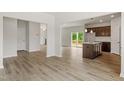 Open-concept living space featuring luxury vinyl flooring, a kitchen island, and sliding glass doors at 95 Cordoba Dr, Franklinton, NC 27525