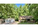 Charming home nestled among mature trees with a detached two-car garage, and stepping stone pathway at 96 Holly Cir, Henderson, NC 27537