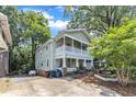 Charming two-story home with a vibrant yellow front door and welcoming double-decker front porches at 1011 Burch Ave, Durham, NC 27701