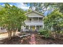 Charming two-story home with a vibrant yellow front door and welcoming double-decker front porches at 1011 Burch Ave, Durham, NC 27701